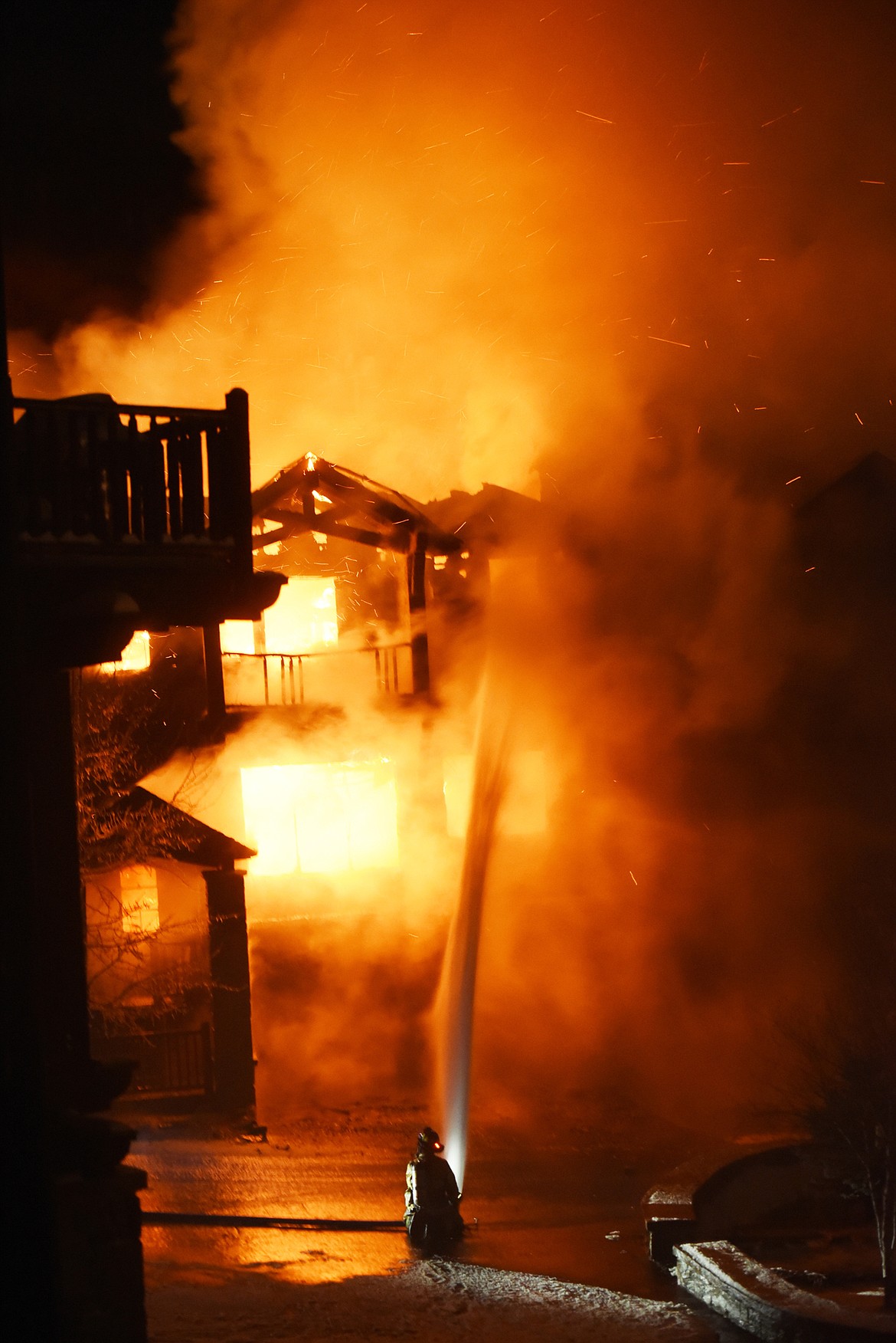 A firefighter battles the fully engulfed townhouse on Slopeside Drive on Big Mountain on Thursday night, Nov. 2, in Whitefish. At 9:42 p.m., Big Mountain Fire and Rescue responded to the report of a structure fire in a residential area near the ski slopes at Whitefish Mountain Resort. They were quickly joined by crews from the Whitefish, Kalispell, Columbia Falls and Evergreen fire departments. Nearly 30 firefighters battled the blaze for about five hours in freezing conditions on snow-packed ground. A sharp wind was another concern for firefighters as they fought to keep the blaze contained.(Brenda Ahearn/Daily Inter Lake)