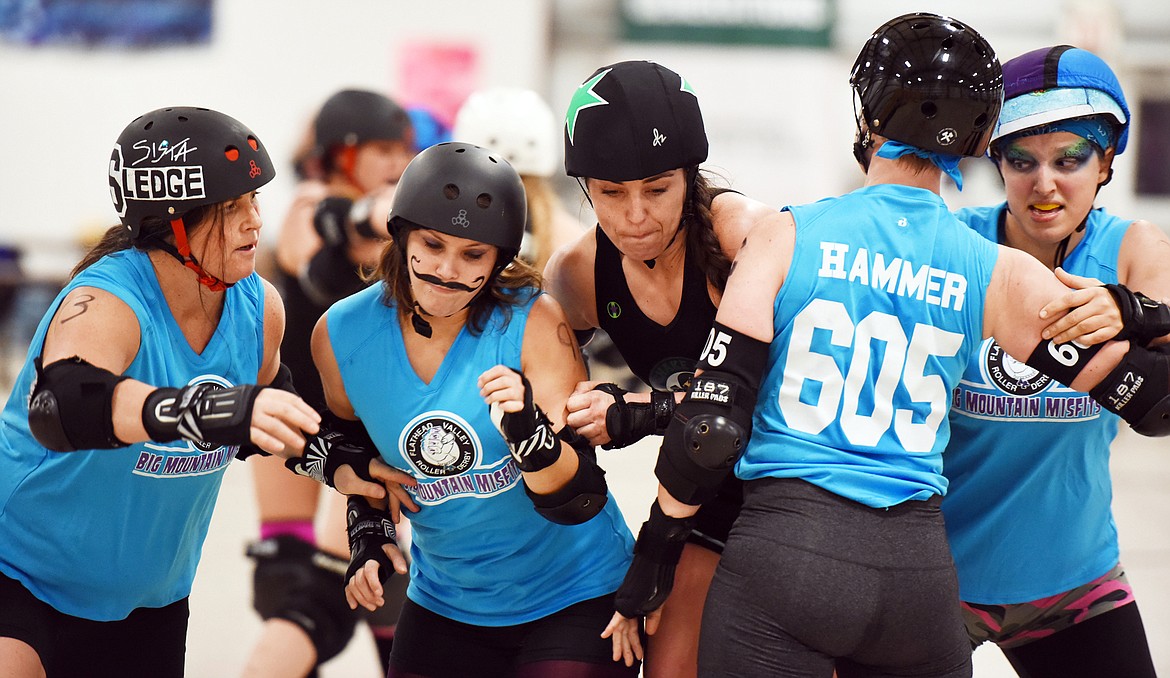 From left, Sonja Kieillis Wildt (Sista Sledge) Erika Wilcox (Pint Size Pistol) Kari Hammer (Hammer) and Shayna Swanson (Ruh-Roh) work to block a Jammer during the match against the Snake Pit Derby Dames of Coeur d&#146;Alene on Saturday, November 18, at the Flathead County Fairgrounds.(Brenda Ahearn/Daily Inter Lake)