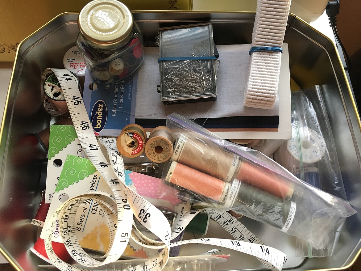 An unopened riveting kit, a Knott's Berry Farm jelly jar filled with buttons and blue rubber bands are specific items Erin Looney found in a tin in a thrift store in Spokane on Wednesday, making her 99 percent certain that this cookie-tin-turned-sewing-kit belonged to her mom, who died of cancer in 1998. The sewing kit disappeared when her belongings were sold with a storage unit about 20 years ago. (Courtesy photo)
