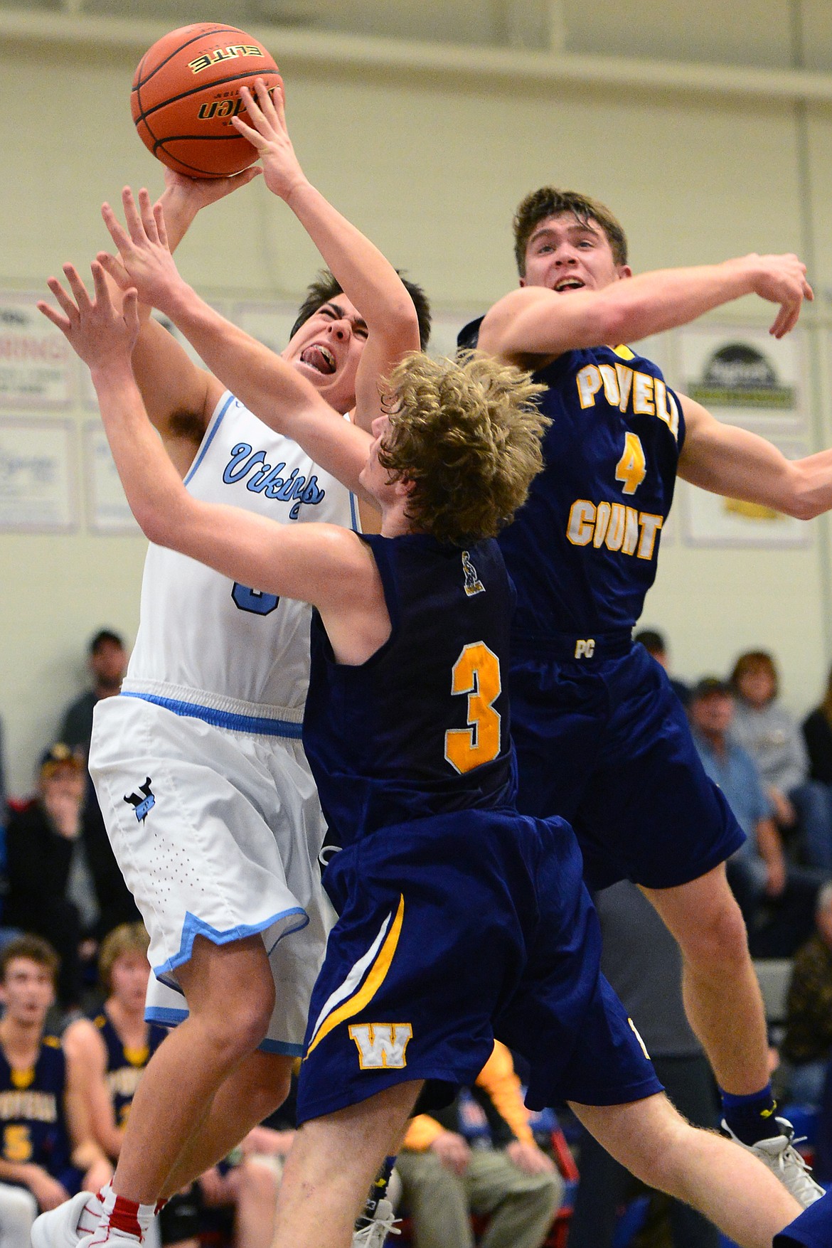 Bigfork's Luke Schmitt drives to the hoop with Deer Lodge's Judd Applegate, center, and Greydon Nicholson defending. (Casey Kreider/Daily Inter Lake)