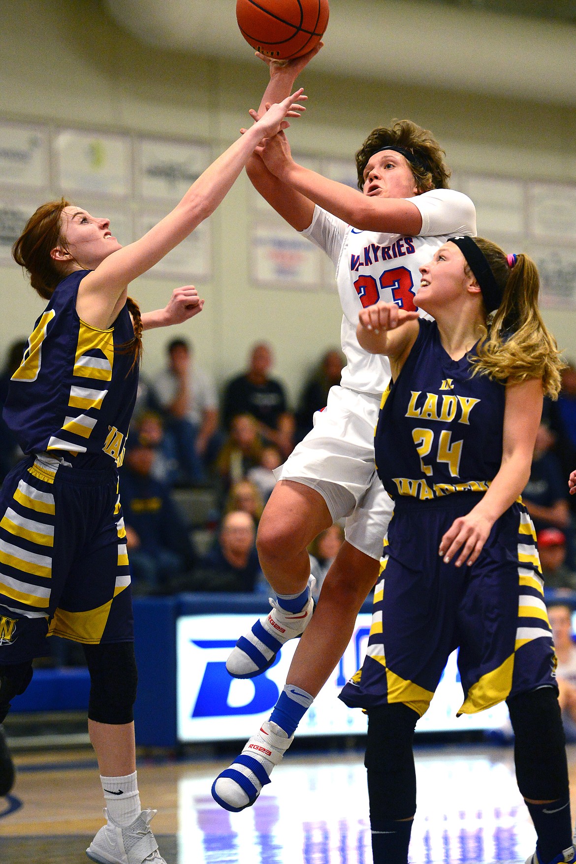 Bigfork's Rakiah Grende drives to the hoop with Deer Lodge's Darcy Walker, left, and Rachel Nicholson defending. (Casey Kreider/Daily Inter Lake)