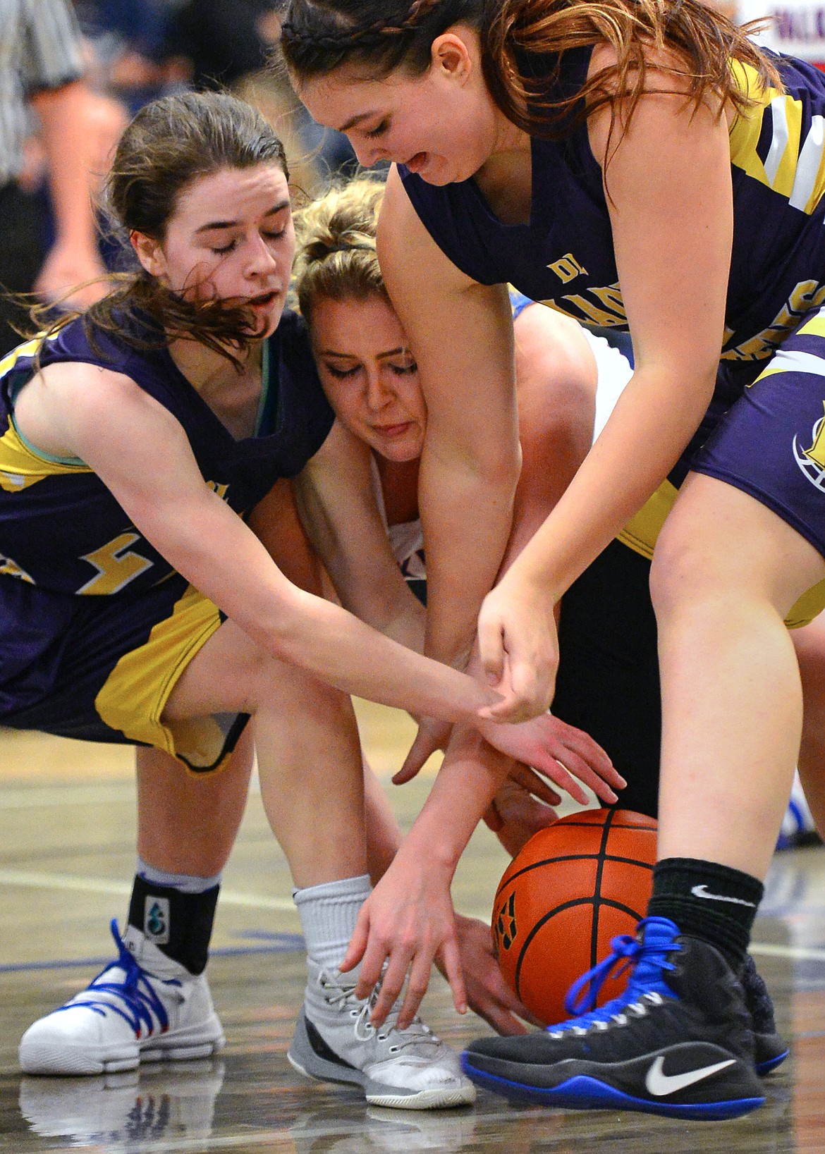 Bigfork's Jaime Berg, center, battles Deer Lodge's Kamryn Johnson, left, and Bailee Johnson for a loose ball. (Casey Kreider/Daily Inter Lake)