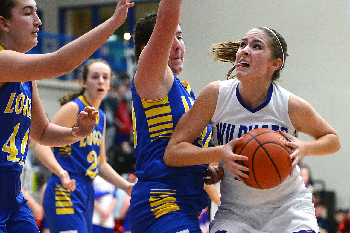 Columbia Falls' Hannah Gedlaman drives to the hoop with Libby's Brooklyn Rainer, left, and McKenzie Proffitt defending. (Casey Kreider/Daily Inter Lake)