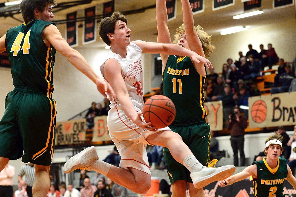 Flathead&#146;s Eric Seaman drives to the hoop between Whitefish defenders Lee Walburn, left, and Mark Anderson. (Casey Kreider/Daily Inter Lake)