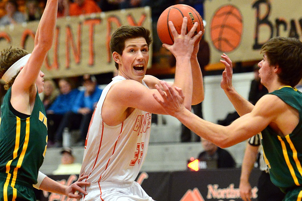 Flathead&#146;s Sam Elliott drives to the hoop between Whitefish defenders Caleb Meehan, left, and Lee Walburn. (Casey Kreider/Daily Inter Lake)