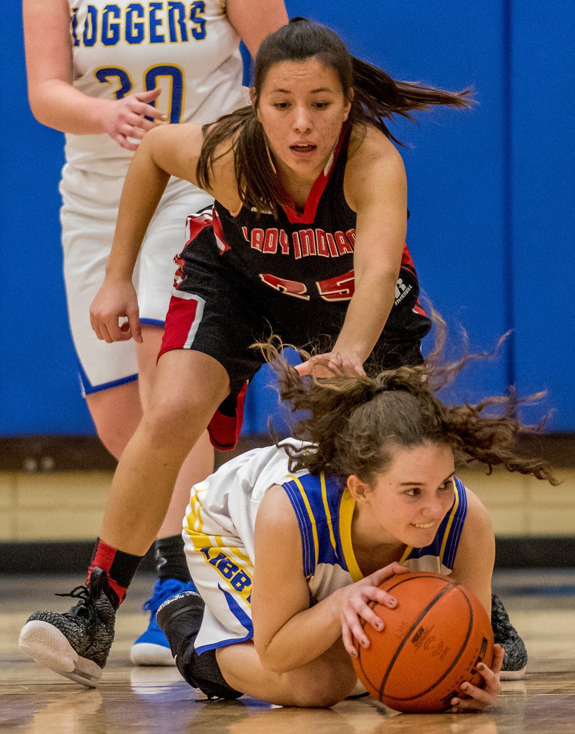 Libby’s Emma Gruber grabs a loose ball before Veronica Reed of Browning can in Saturday’s game in Libby. See story and more photos on page B2. (John Blodgett/The Western News)
