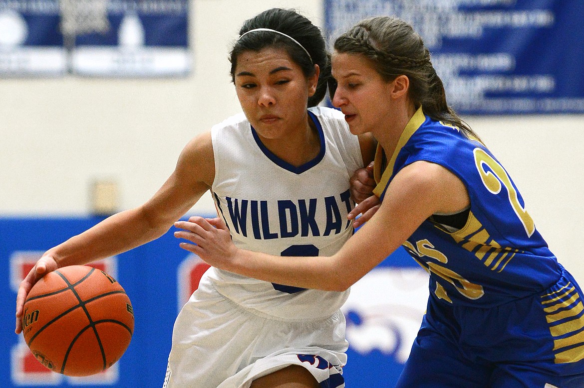 Columbia Falls' Dani Douglas drives to the hoop with Libby's Linsey Walker defending. (Casey Kreider/Daily Inter Lake)