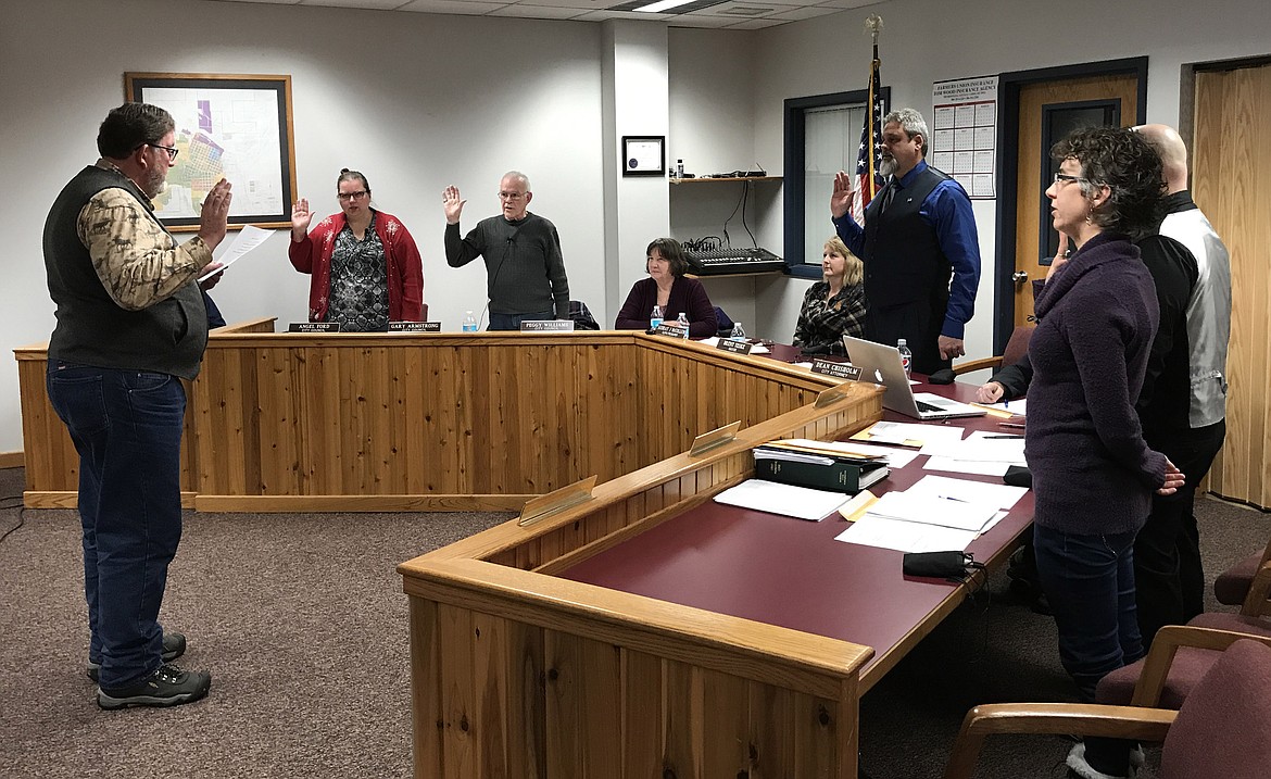 Mark Peck, left, Libby’s representative on the Lincoln County Commission, swears in recently elected members of the Libby City Council — from left, Angel Ford, Gary Armstrong, Mayor Brent Teske, Gary Beach (partly obscured), and Kristin Smith — at the City Council meeting Tuesday, Jan. 2. (John Blodgett/The Western News)