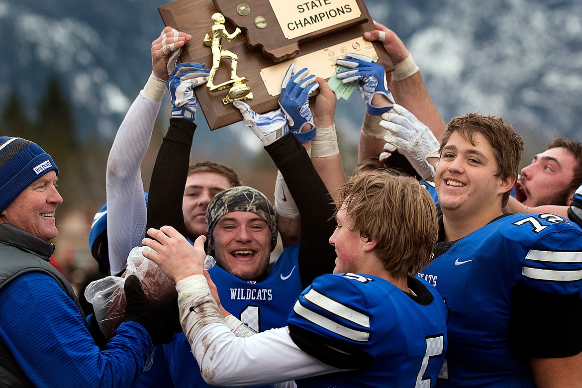 Surrounded by teammates, KJ Arends hoists the state trophy. (Jeremy Weber photo)