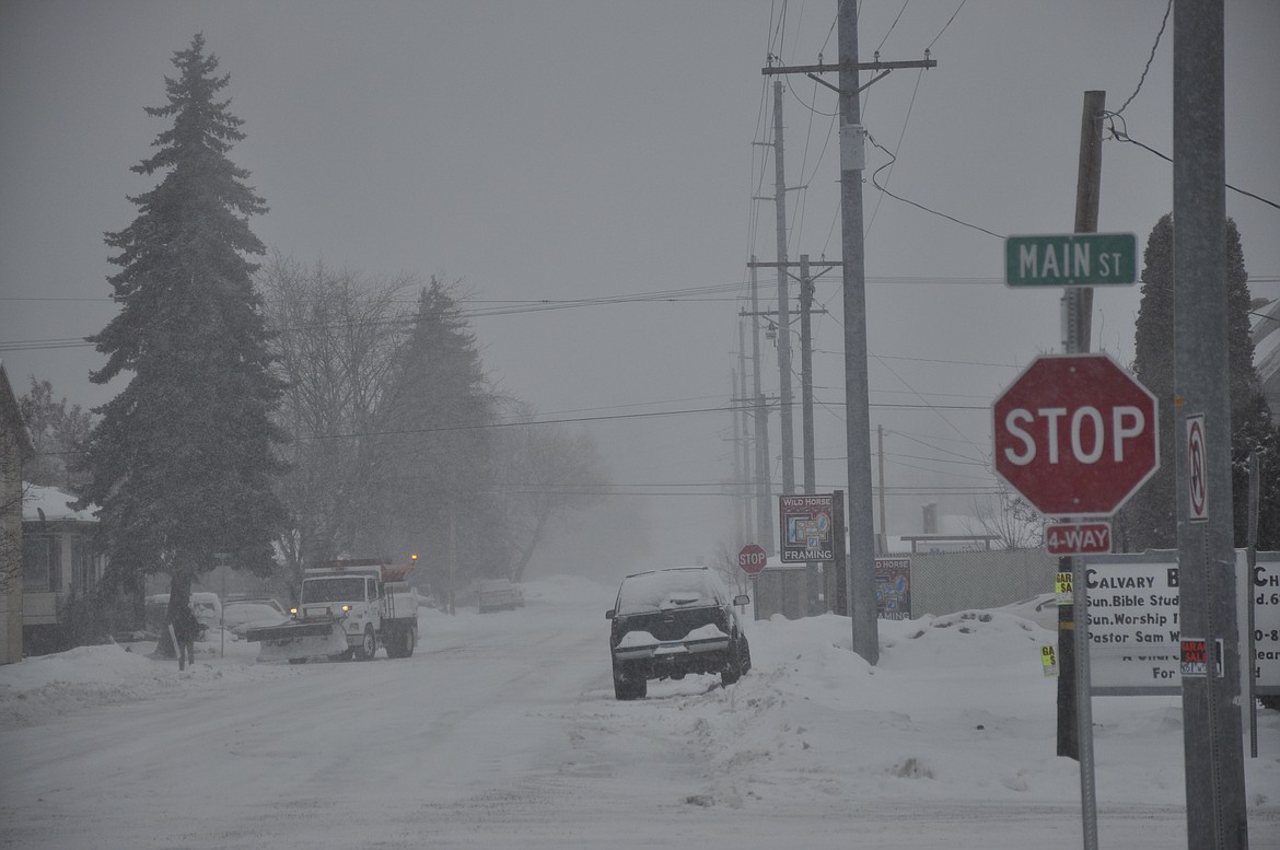 A Polson city street plow maintains roadways around the downtown area late Friday morning, just as a winter storm sets in. (Ashley Fox/Lake County Leader)