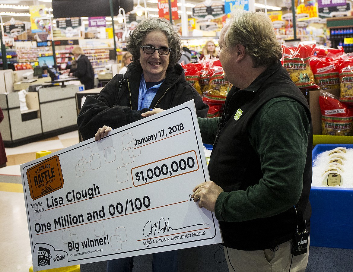 LOREN BENOIT/Press
Post Falls resident Lisa Clough receives a $1,000,000 check from Idaho Lottery public information specialist David Workman Wednesday morning at Super 1 Foods in Post Falls. The Idaho $1,000,000 Raffle ended Dec. 31 and the winning numbers were drawn Jan. 2.