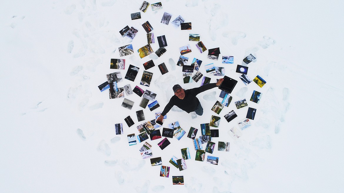 Artist Mike Potter poses on the shoreline of Whitefish City Beach along Whitefish Lake with 100 prints of his paintings Wednesday morning, Jan. 17. (Courtesy of Mike Potter)