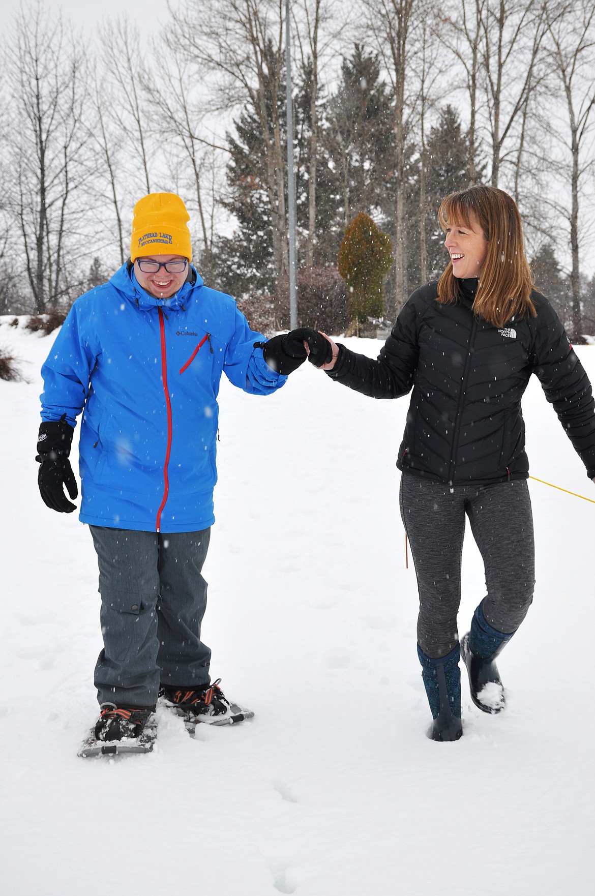 Carolyn Wallace accompanies her son, Robbie Hayes, as he snowshoes Thursday afternoon in Polson. (Jason Blasco/Lake County Leader)