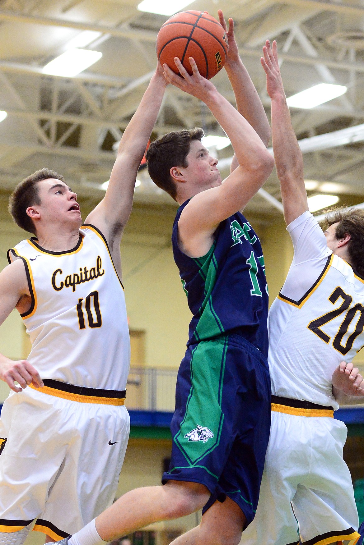 Glacier&#146;s Drew Engellant drives to the hoop between Helena Capital defenders Ty McGurran, left, and Chase Spotorno during a 44-38 win at Glacier High School on Saturday. (Casey Kreider/Daily Inter Lake)