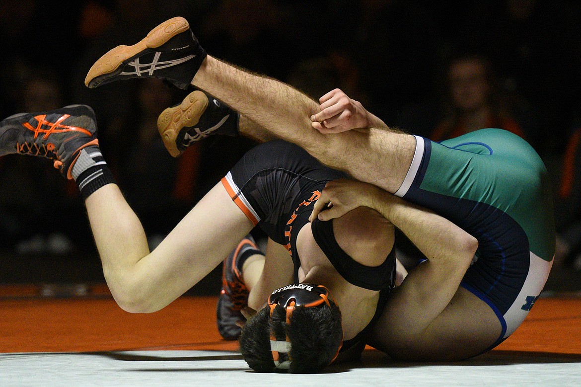 Flathead's Dominic Battello, left, works toward a pin of Glacier's Tristan Little at 120 pounds on Thursday at Flathead High School. (Casey Kreider/Daily Inter Lake)