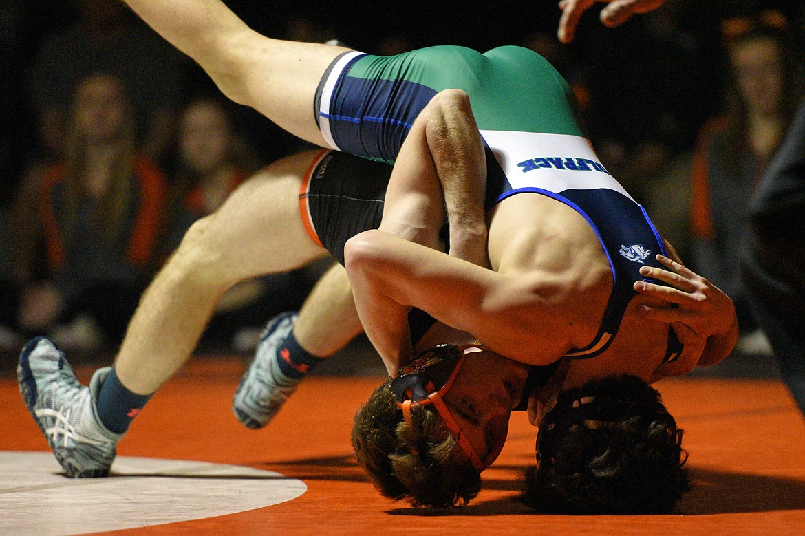 Glacier's Lane Wilson, top, works toward a pin of Flathead's Braden Comer at 126 pounds on Thursday at Flathead High School. (Casey Kreider/Daily Inter Lake)