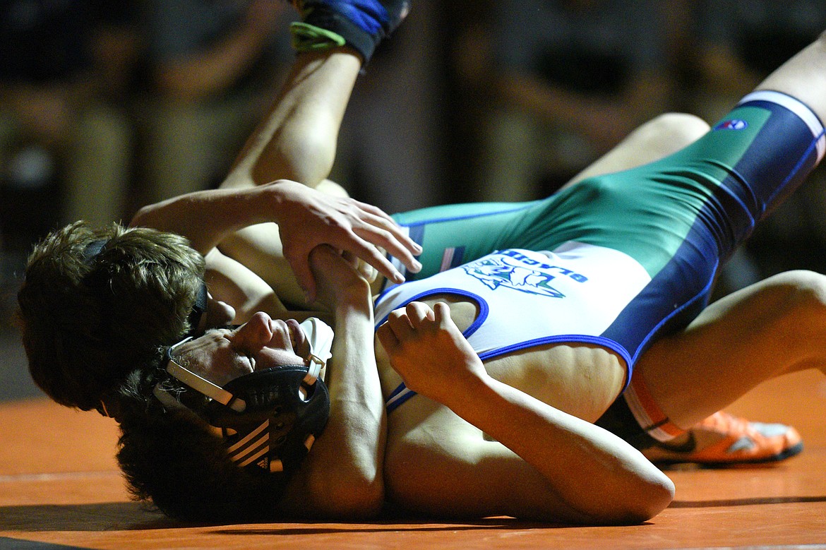 Flathead's Bryce Shaffer works toward a pin of Glacier's Kael Willis at 113 pounds on Thursday at Flathead High School. (Casey Kreider/Daily Inter Lake)