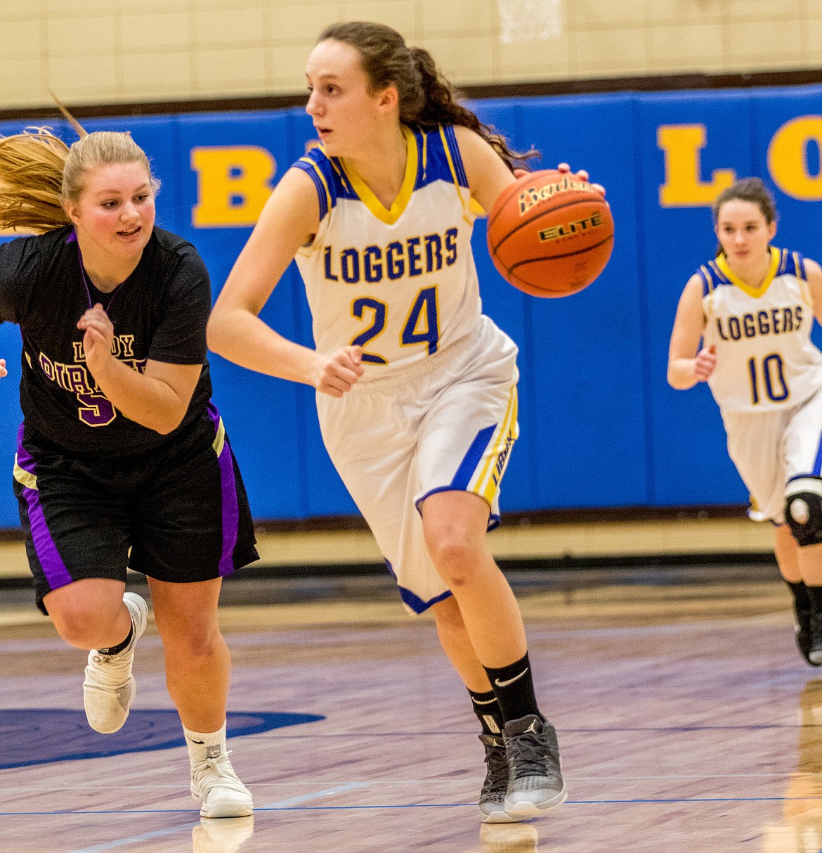 Jayden Winslow of Libby heads toward the basket followed by Polson's Jaycee Frydelund and Lady Logger Emma Gruber Saturday. (John Blodgett/The Western News)