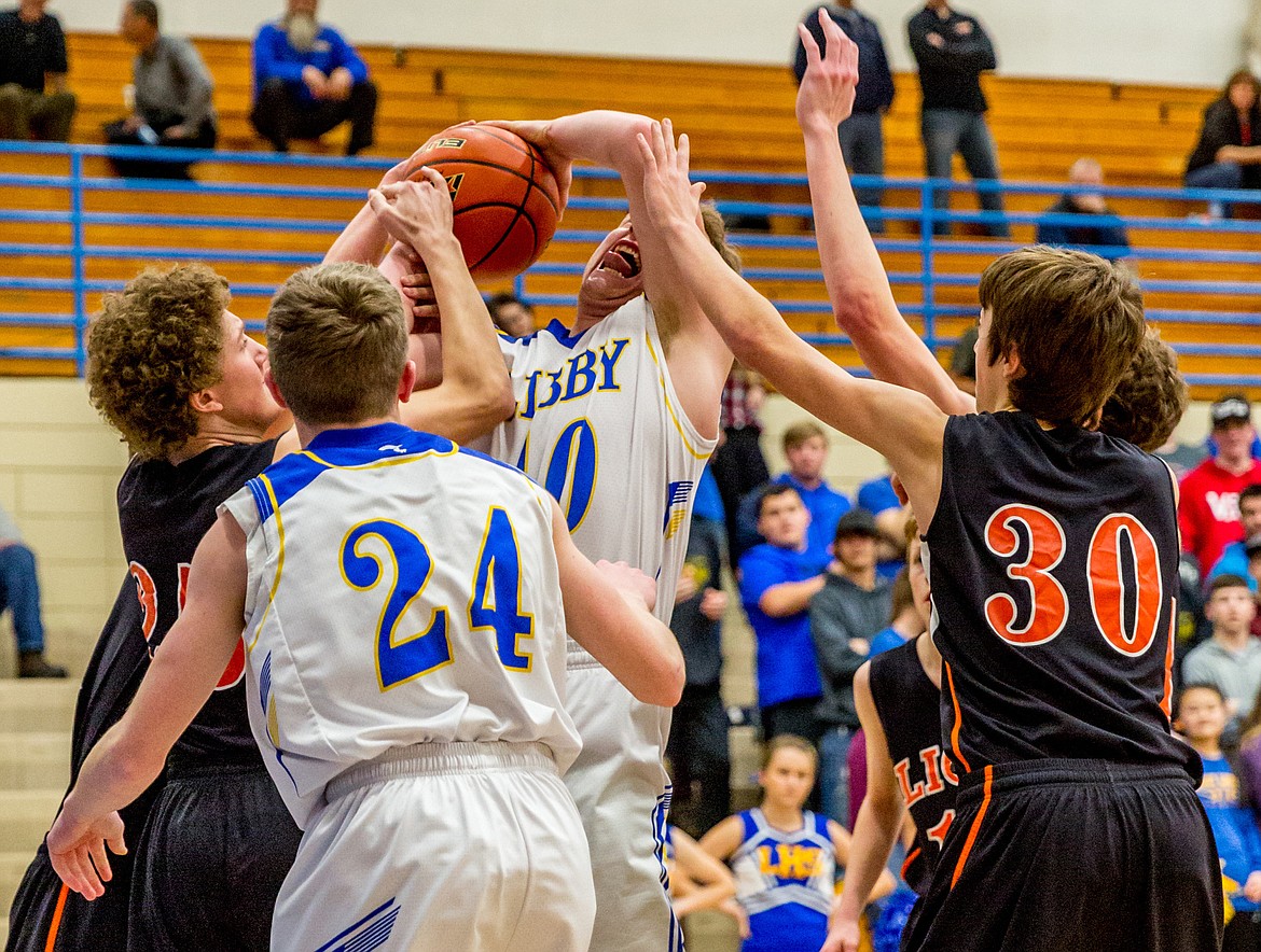 Libby&#146;s Nik Jones, center, gets fouled by Eureka&#146;s Cory Chaney, left, in Tuesday&#146;s Battle of the Kootenai.