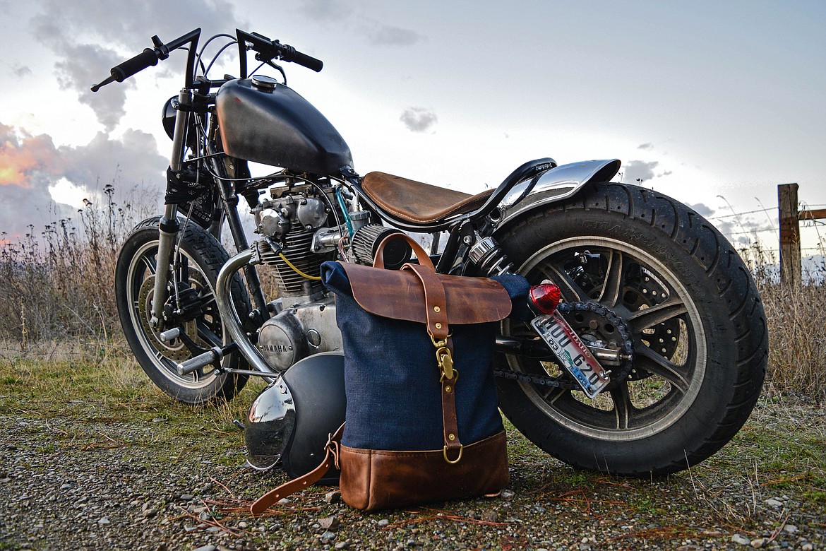 A roll-top, denim and leather motorcycle backpack, one of many durable, traditional  items sold by Chad Von Lind.