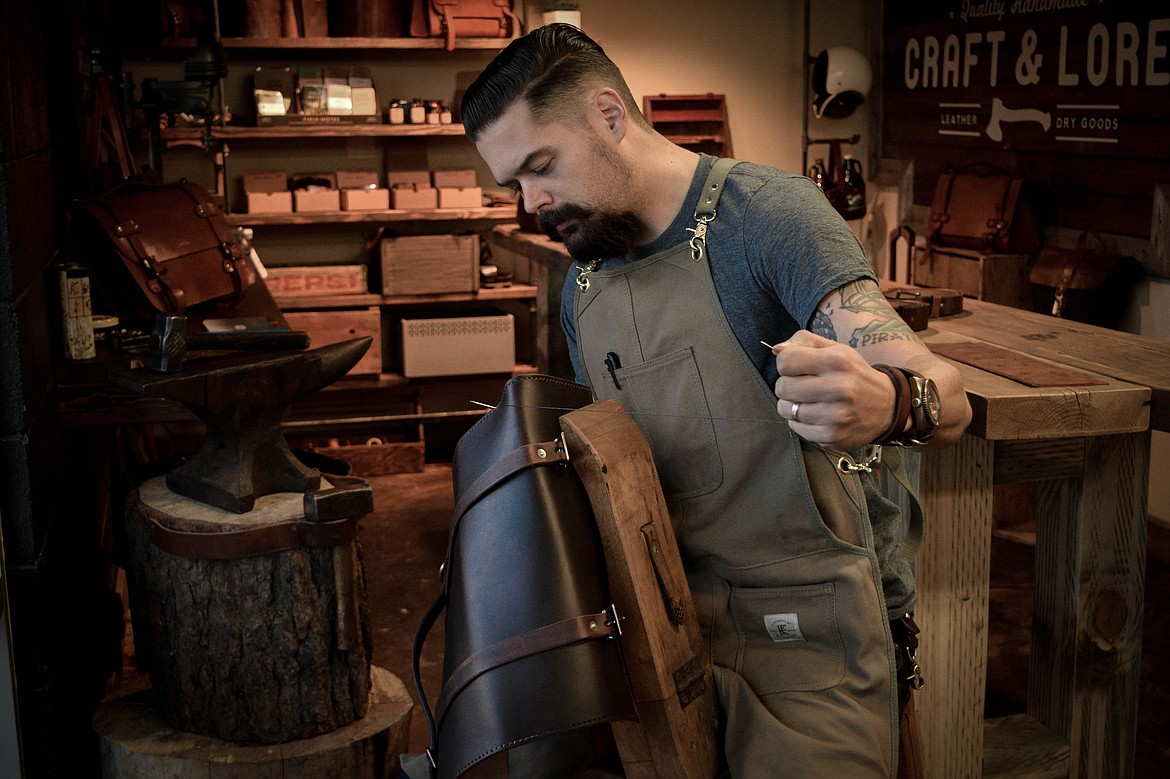 Chad Von Lind, proprietor of Craft &amp; Lore, hand-stitches one of his products.