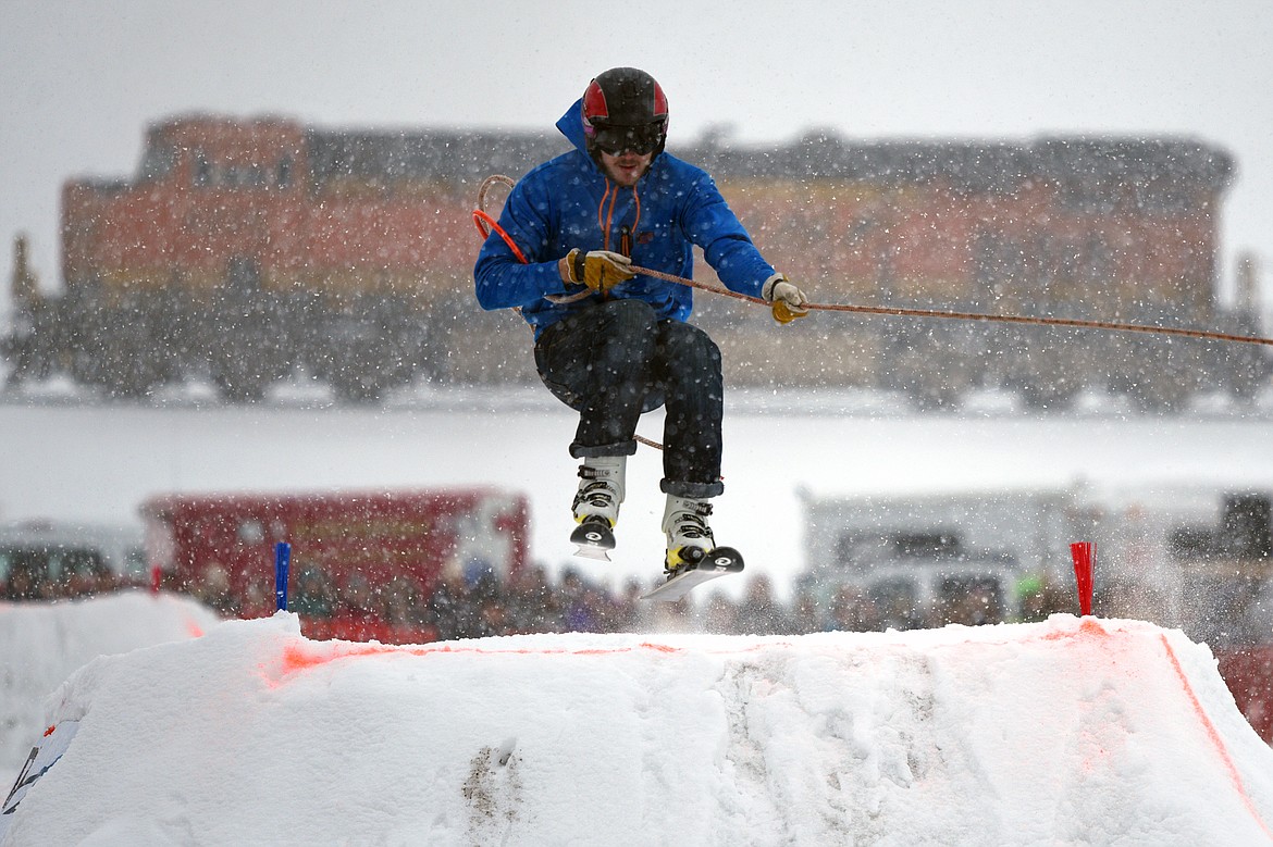 A skier goes over a jump on the course as a train passes in the background at Whitefish Skijoring at Big Mountain Ranch on Saturday. (Casey Kreider/Daily Inter Lake)