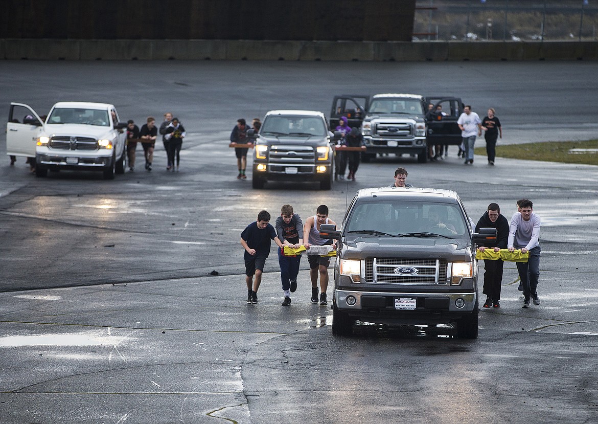 LOREN BENOIT/PressOver 50 Post Falls High School wrestlers push Auto Source trucks 20 laps around the Stateline Speedway Wednesday afternoon after the team completed their annual fundraising Push For the Gold challenge.