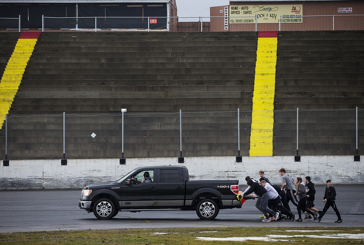 LOREN BENOIT/PressPost Falls High School wrestlers push a Ford Super Duty truck around the Stateline Speedway Wednesday afternoon after completing their Push for the Gold Challenge.