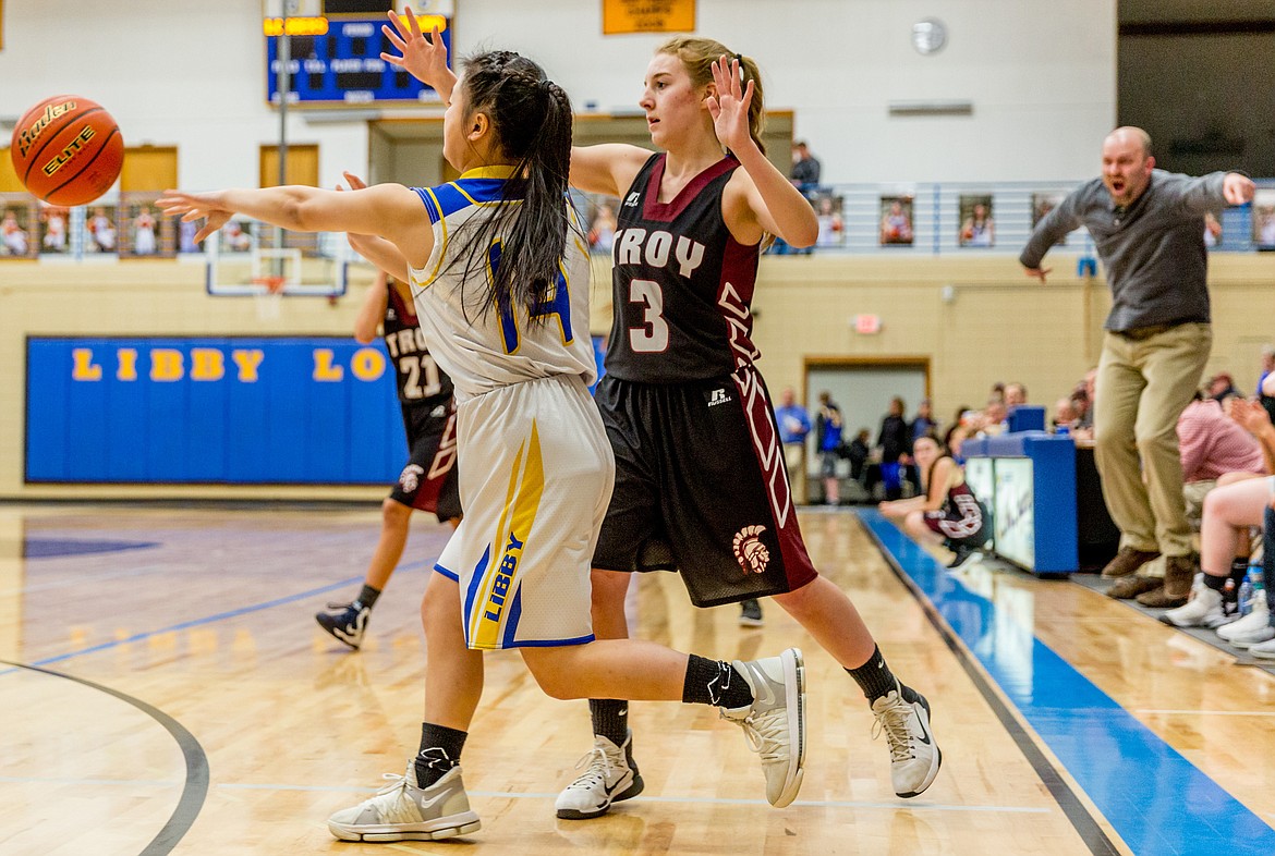 Lady Logger Syd Gier passes while being guarded by Troy&#146;s Annie Day Thursday, Jan. 25. (John Blodgett/The Western News)