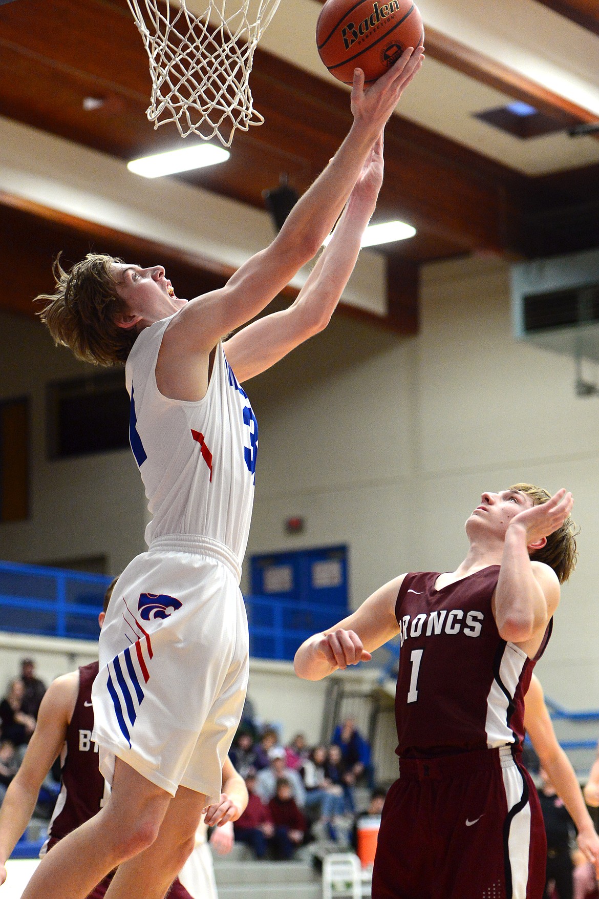 Columbia Falls&#146; Matthew Morrison lays in two points in front of Hamilton&#146;s Camron Rothie at Columbia Falls High School on Saturday. (Casey Kreider/Daily Inter Lake)