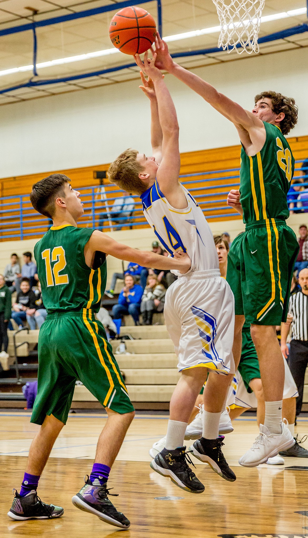 Libby&#146;s Chandler Bower is fouled by Whitefish&#146;s Daniel Davis, left, and blocked by Sam Menicke during Friday night&#146;s game in Libby. (John Blodgett/The Western News)