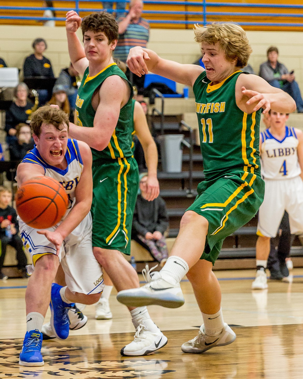 Libby&#146;s Nik Jones passes to a teammate under heavy Whitefish guard Friday night in Libby. (John Blodgett/The Western News)