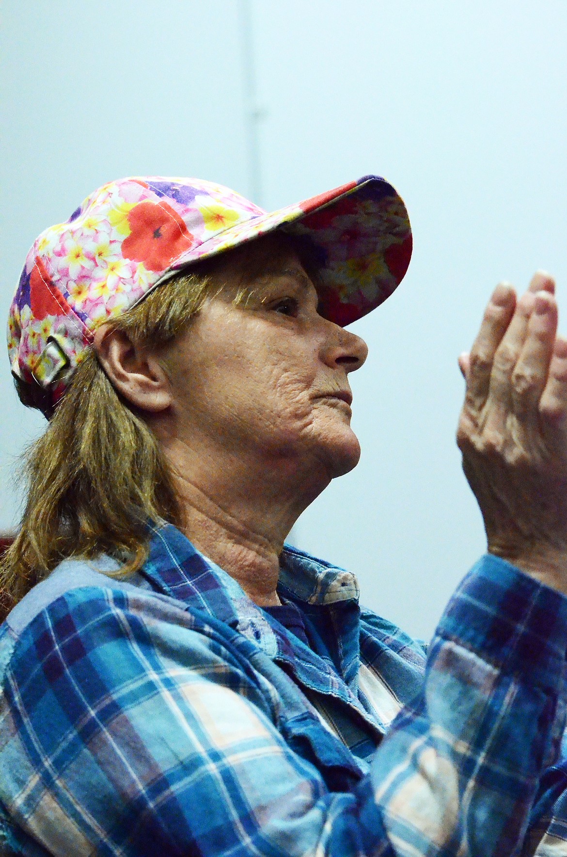 A woman stands to applaud a speaker at the Paradise rally.