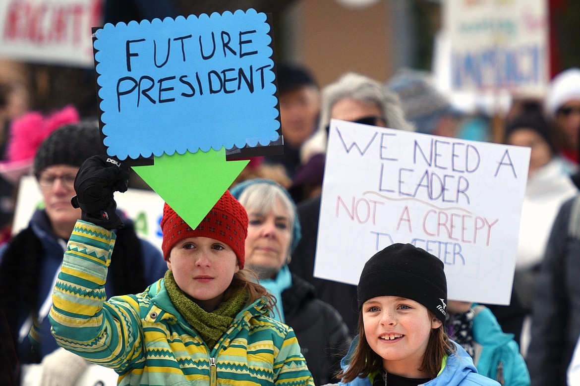 Nalani River, left, 11, of Somers, and Maia Dodge, 9, of Kila, watch one of many speakers at the Women's March in Depot Park in downtown Kalispell on Saturday, Jan. 20. (Casey Kreider/Daily Inter Lake)