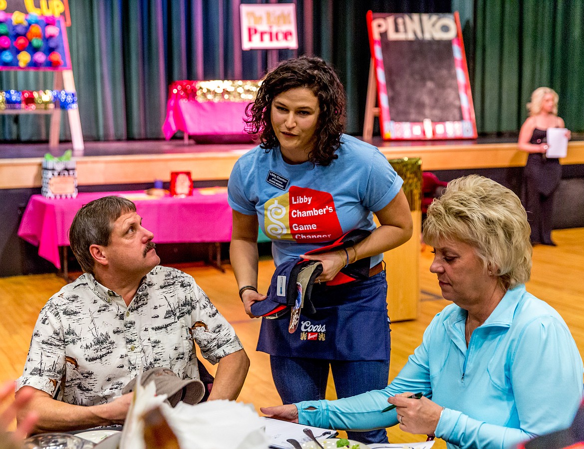 Liz Whalen, center, the treasurer for the Libby Chamber of Commerce, sells hats donated by local businesses for use in the &#147;Heads and Tails&#148; game at the Chamber&#146;s banquet Saturday night at the Libby Memorial Events Center. (John Blodgett/The Western News)