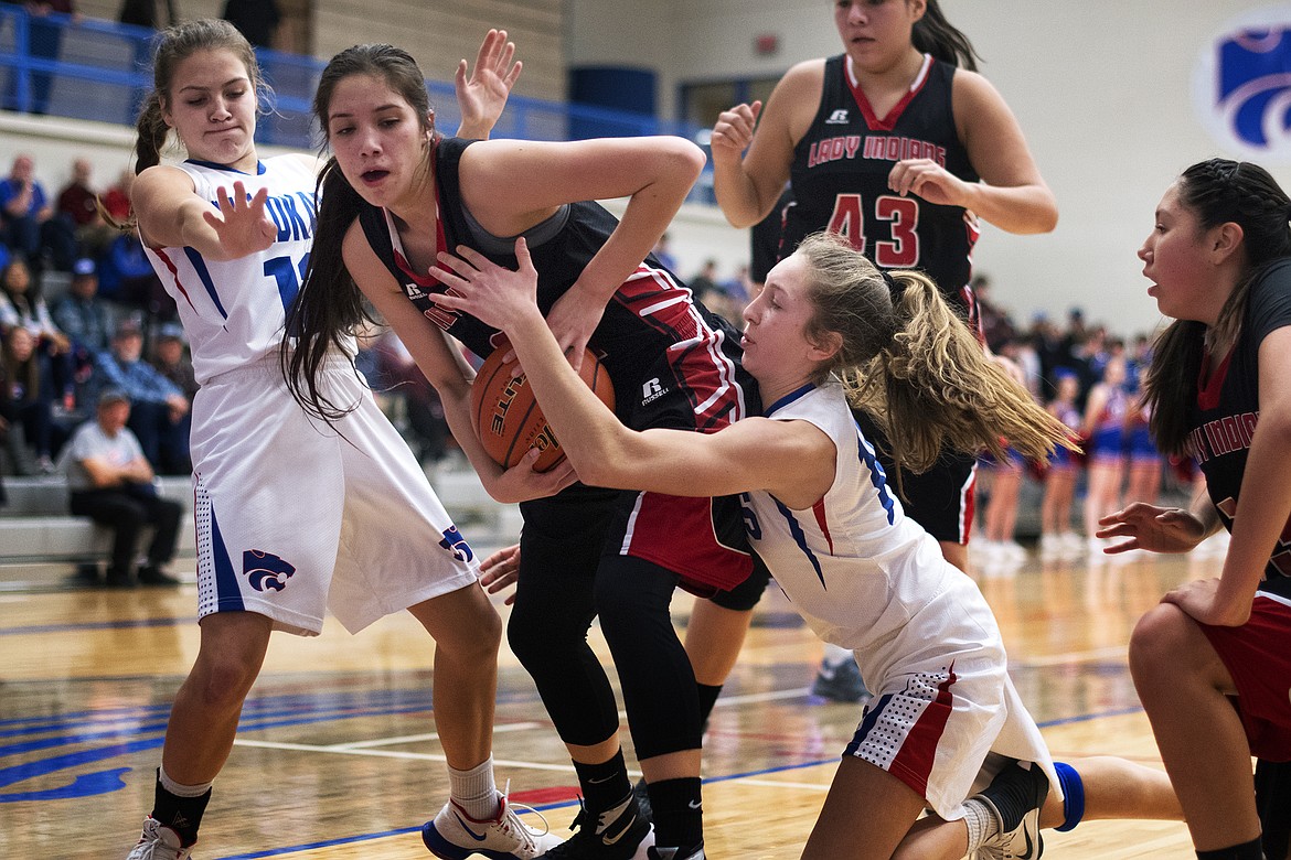 Wildkats LaKia Hill (left) and Josie Windauer attempt to steal the ball from a Browning player Thursday. (Jeremy Weber photo)