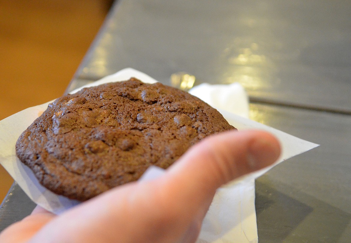 A customer enjoys the Triple Chocolate Cookie at Swift Creek Cafe. (Heidi Desch/Whitefish Pilot)