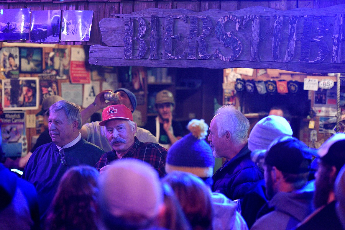 Former Whitefish Mountain Resort ski patrol manager and current director of operations Chester Powell (in the red hat) addresses the crowd with former ski patrol manager/hill manager Dale Evenson, left, and former patrol manager Terry King, right, during the Frabert awards at The Bierstube on Wednesday, Jan. 17. (Casey Kreider/Daily Inter Lake)