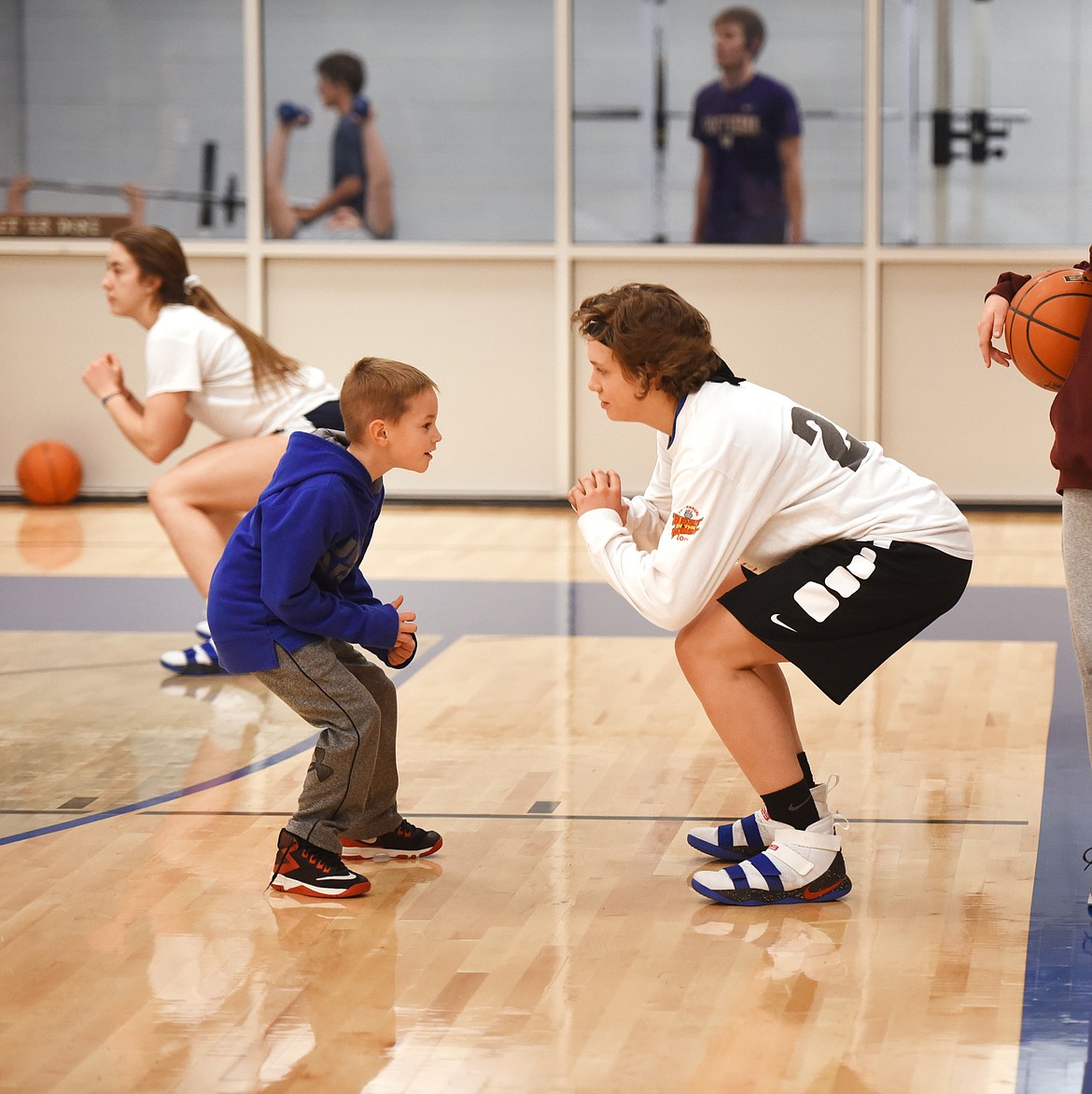 Rakiah Grende warms up for basketball practice on Monday afternoon, January 29, at Bigfork High School as Trae Dunlock, the son of assistant coach Cortnee Dunlock, keeps pace with her.(Brenda Ahearn/Daily Inter Lake)