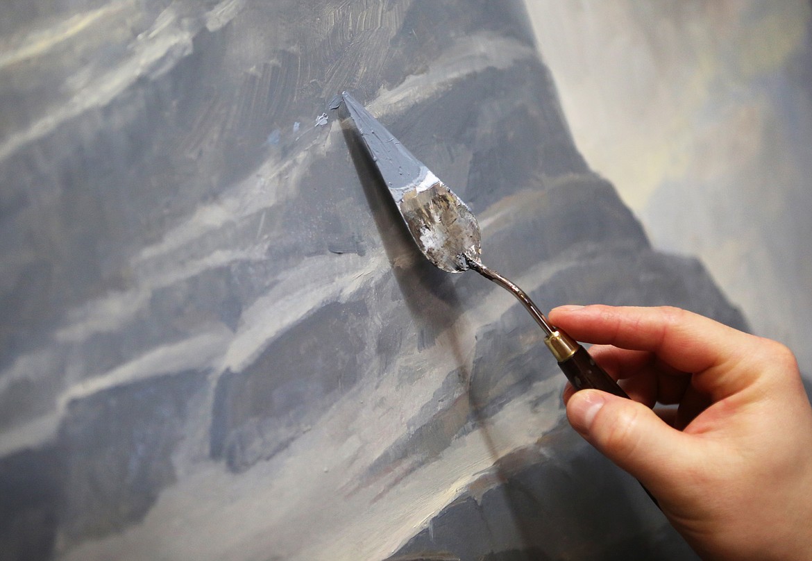 Artist Kenneth Yarus applies paint to a landscape piece in his Kalispell studio Tuesday. (Mackenzie Reiss/Daily Inter Lake)