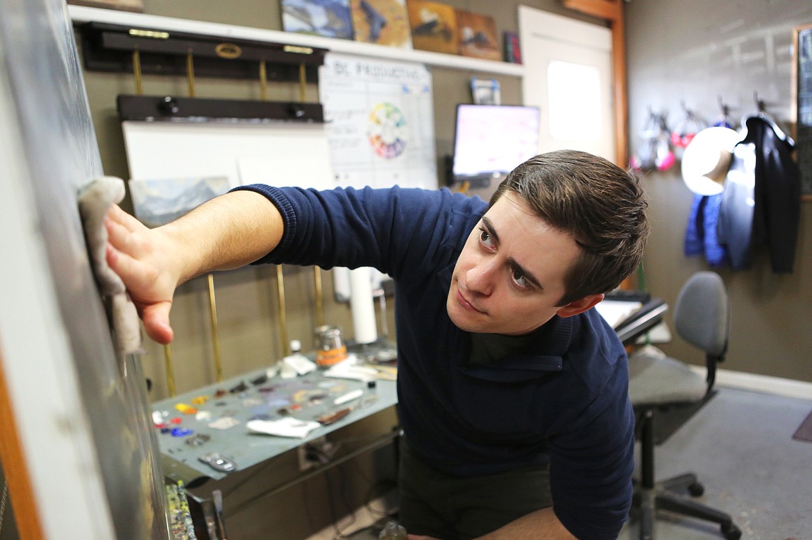 Kenneth Yarus applies walnut oil to a painting in progress so he can continue working on the piece. (Mackenzie Reiss/Daily Inter Lake)