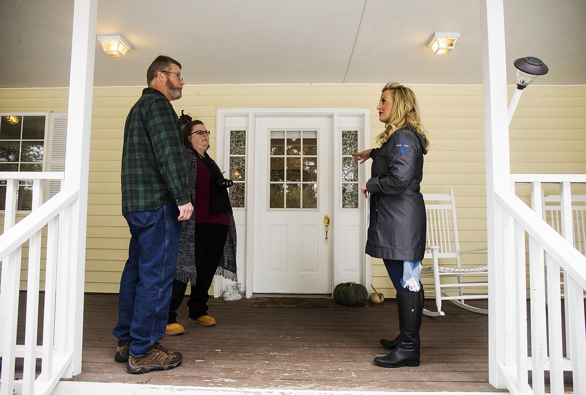 Coldwell Banker Schneidmiller Realty agent Michaela Corcoran-Hall, right, gives a brief overview to California couple Karen and Michael Lind before entering a house during a showing Wednesday afternoon in Rathdrum. (LOREN BENOIT/Press)