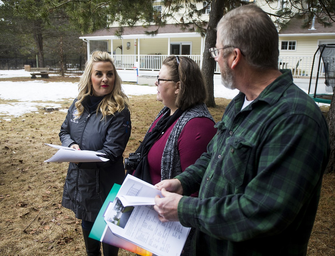 Coldwell Banker Schneidmiller Realty agent Michaela Corcoran-Hall, left, discusses acreage with California couple Karen and Michael Lind during a showing Wednesday afternoon in Rathdrum. (LOREN BENOIT/Press)