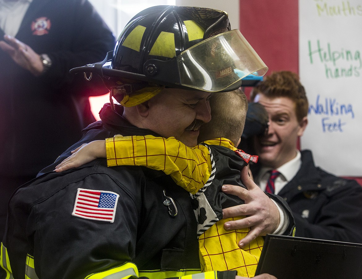 Firefighter Burt Maines gives Landon Hill, 4, a hug at Landon's Make-A-Wish surprise party Tuesday morning in Coeur d'Alene. (LOREN BENOIT/Press)