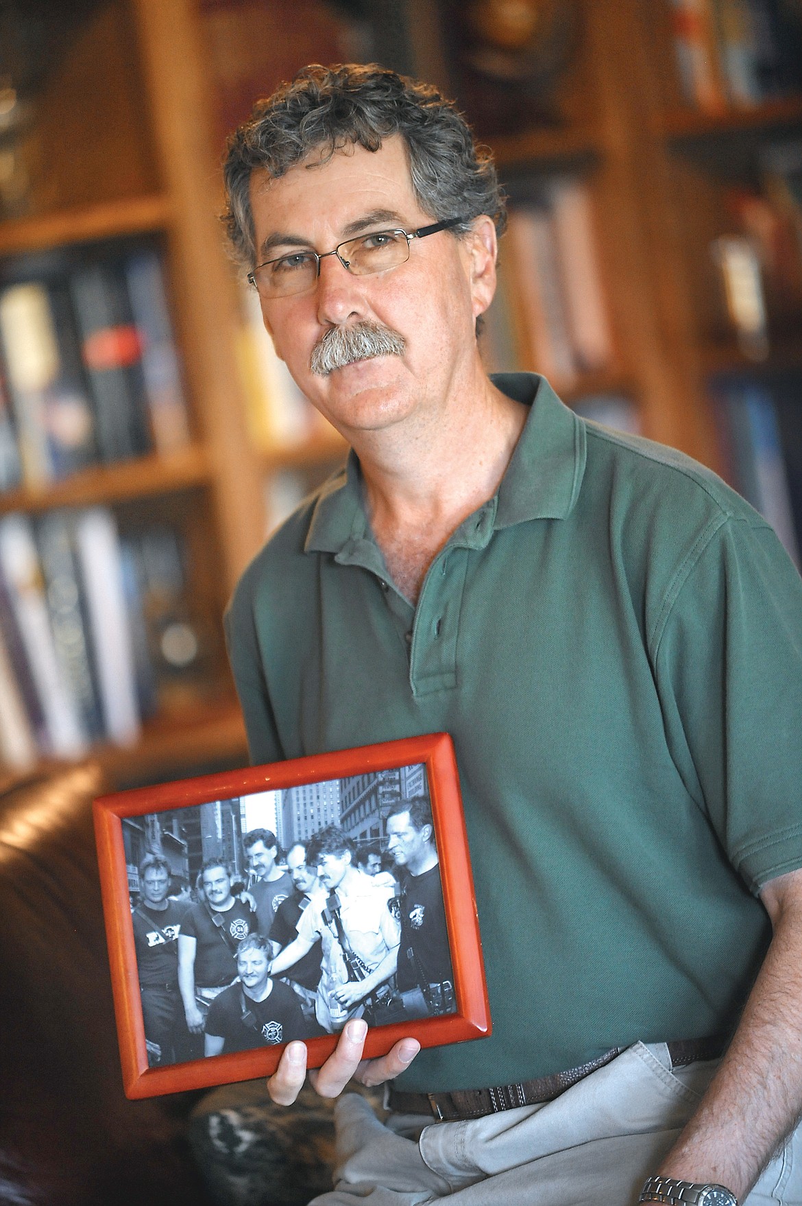 Brenda Ahearn/Daily Inter LakeRetired New York City Firefighter Kevin Shea, who lives near Kalispell, holds a photograph of group of fellow firefighters taken shortly after a 1991 rescue. Of the seven men, three died while responding  the Sept. 11 terrorist attacks and two were badly injured in other fires. Shea, shown third from the left in the back row, survived the 1993 World Trade Center bombing and spent a month helping with the recovery effort after the Sept. 11, 2001 attacks.