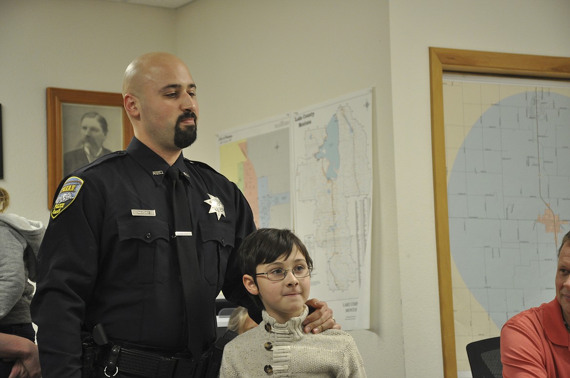 RONAN POLICE Officer Joel Diaz, left, stands with son Aaron as he is sworn in as the department's newest police officer, bringing the department to full staff. (Ashley Fox/Lake County Leader)