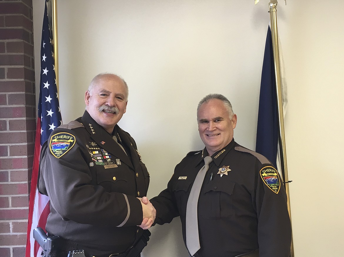 LAKE COUNTY Sheriff Don Bell, left, shakes hands with Chaplain James Pettit after he was sworn in last week. (Ashley Fox/Lake County Leader)