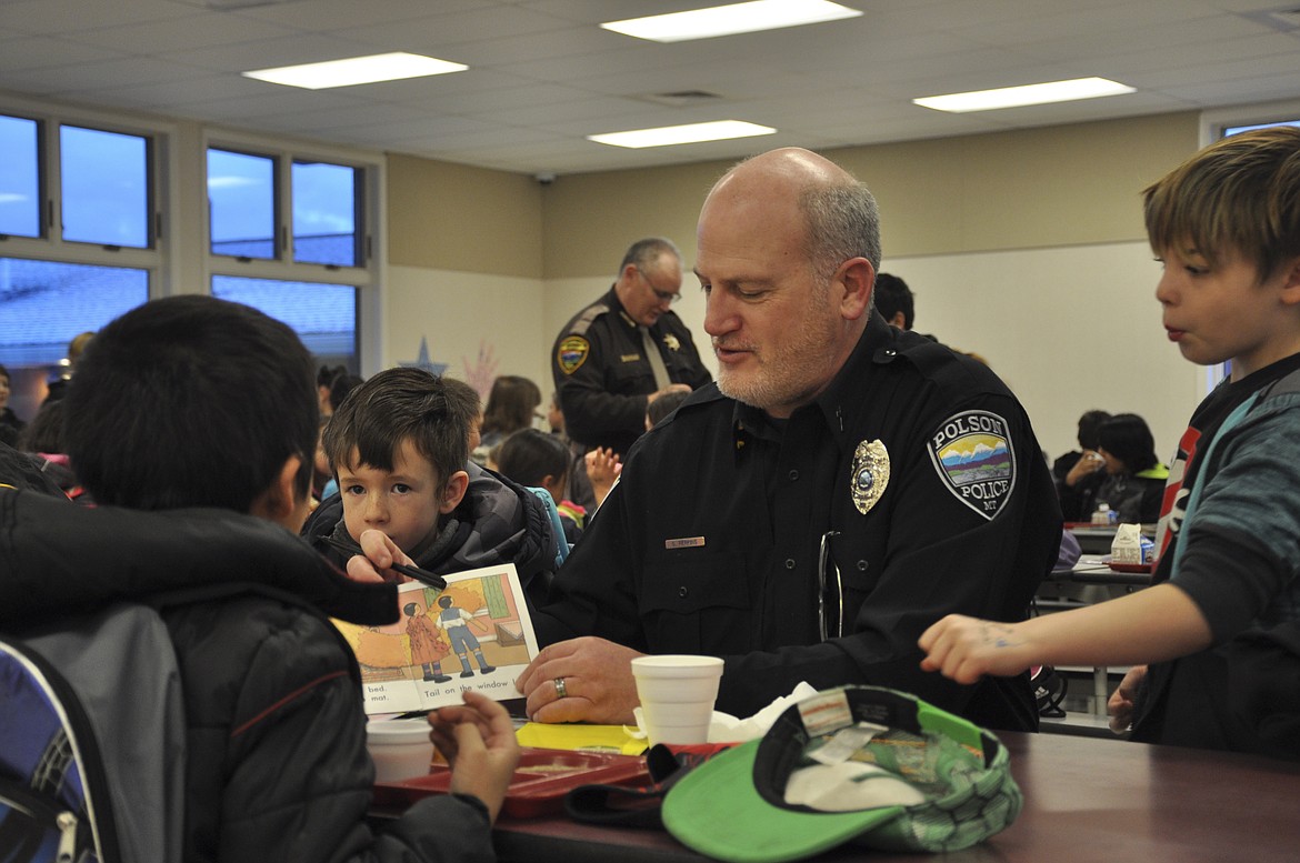 POLSON POLICE Department Chaplain Gregg Perkins reads a story to students during Role Model Readers at K.W. Harvey Elementary in Ronan. (Ashley Fox/Lake County Leader)