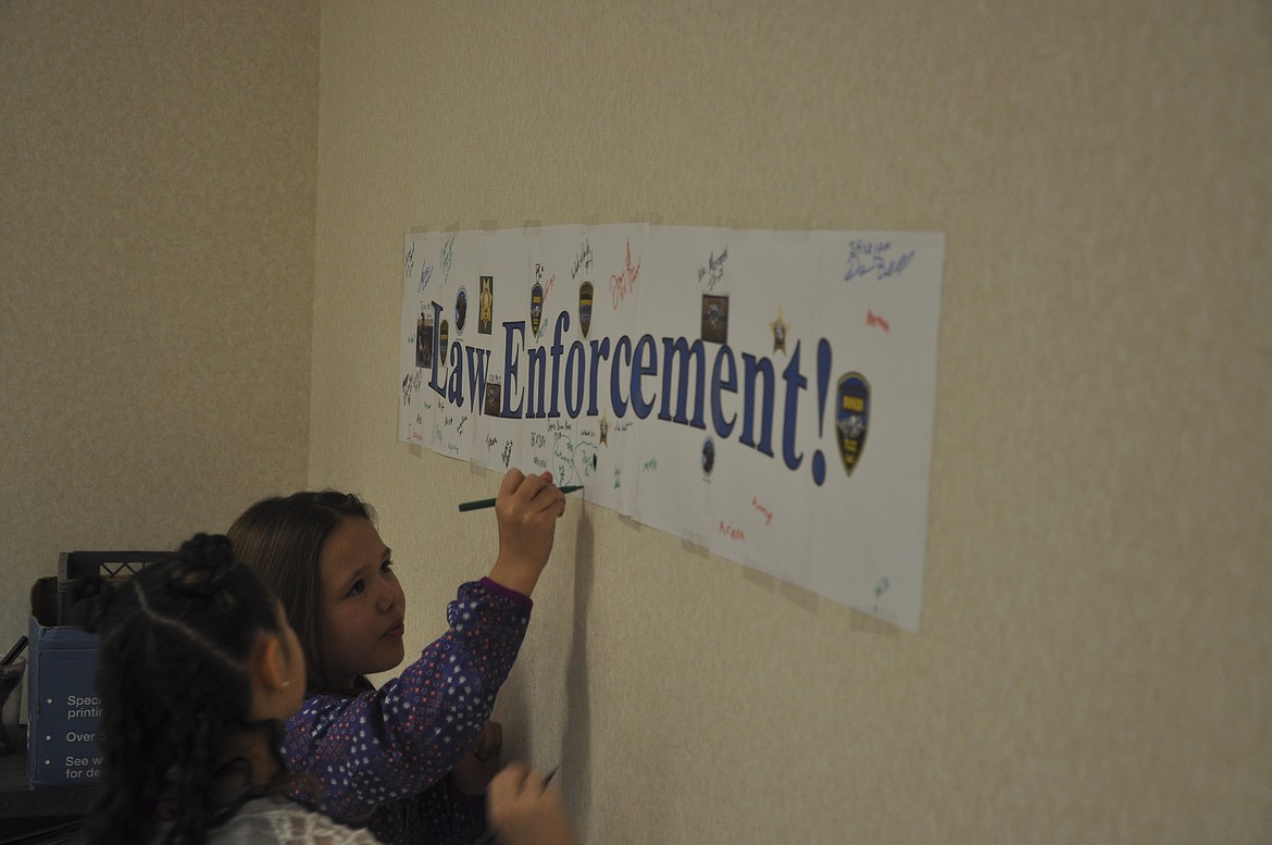 STUDENTS AT K.William Harvey Elementary in Ronan signed a banner made for law enforcement that was on display last week when officers spent the morning reading and answering questions. (Ashley Fox/Lake County Leader)