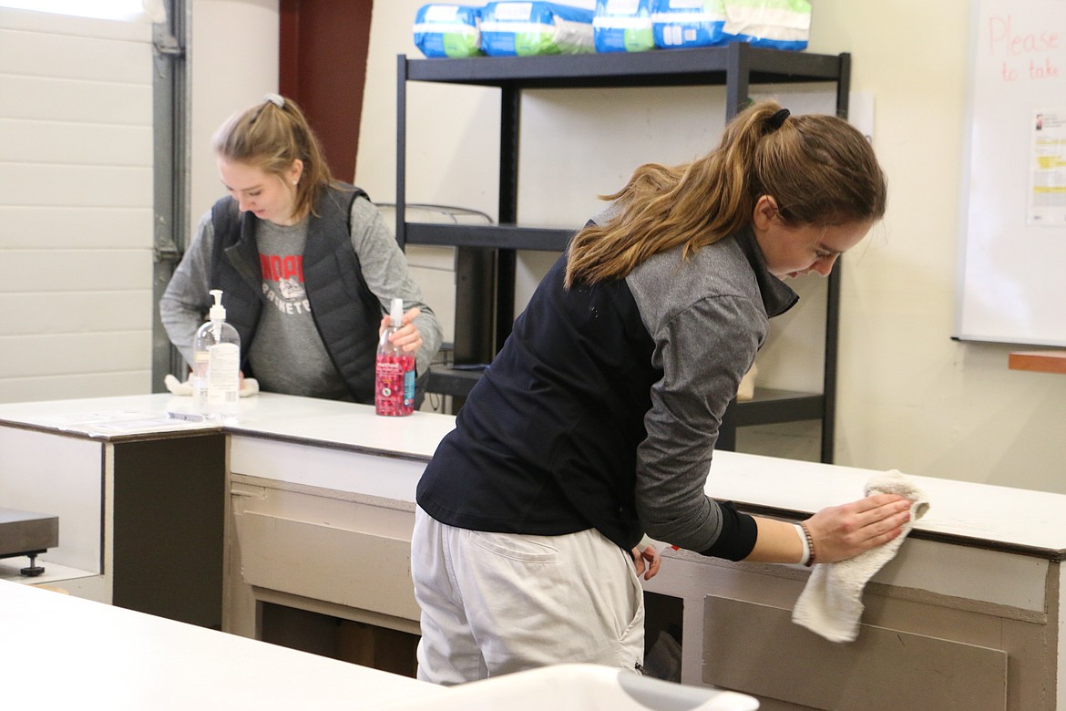 (Photo by MARY MALONE)
Grace Kirscher and Trinity Golder help out as the Sandpoint High School girls varsity team volunteered at the Bonner Community Food Bank on Wednesday to help do some cleaning and pack up food for the Backpack program, which feeds kids from low-income families in the Lake Pend Oreille School District.